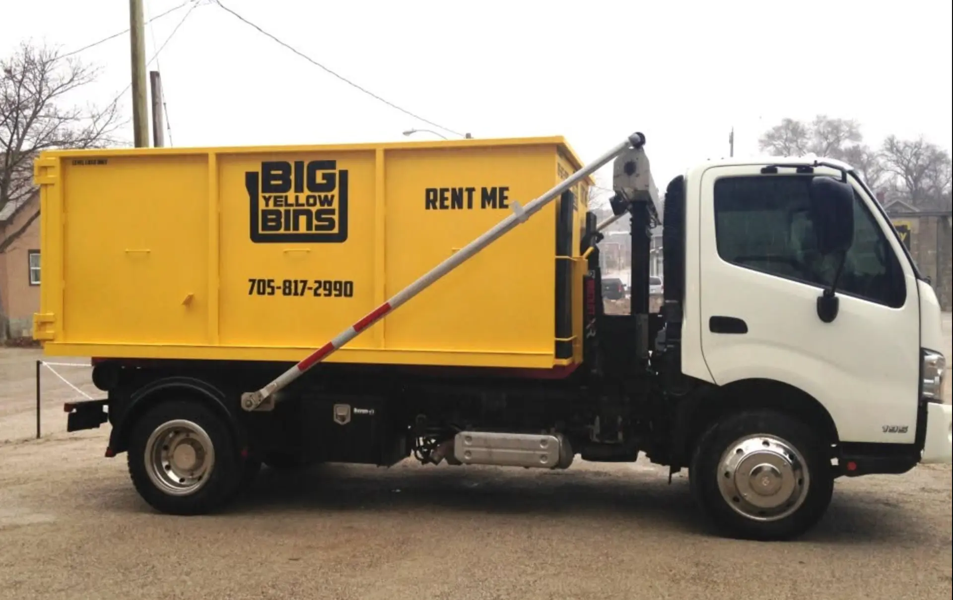 Big Yellow Bins roll-off truck carrying a yellow bin across Simcoe County